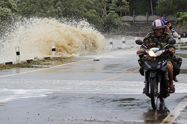 A motorcyclist rides among crashing waves at a beach in Chumphon. (Photo with friendly support from Bangkok Post by Amnard Thongdee)