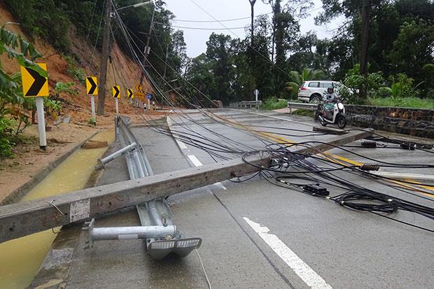 Electricity poles brought down by fallen rocks block a road on Koh Phangan in Surat Thani on Monday. (Photo Credit @ Bangkokpost.com by Supapong Chaolan) 